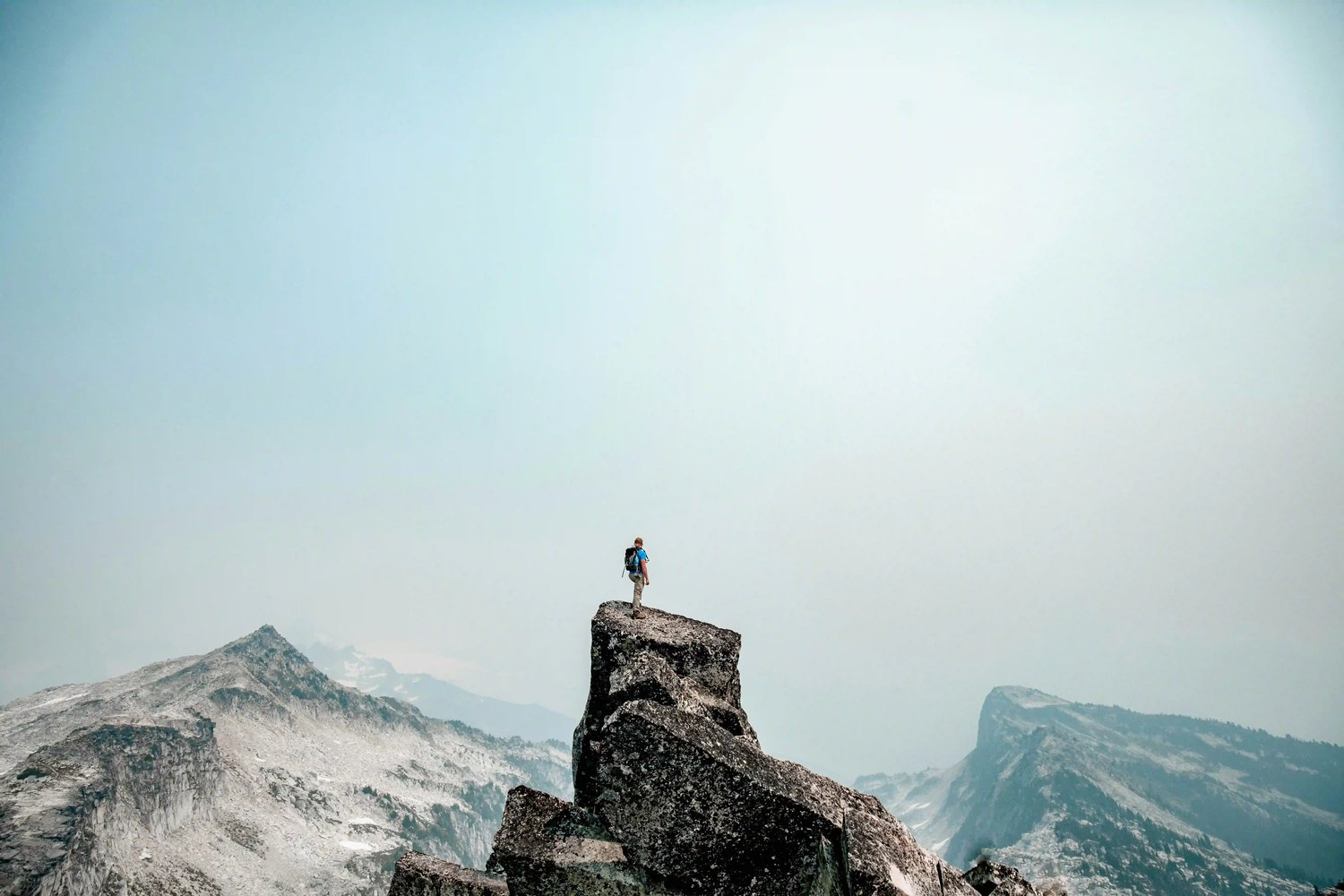 adventure-hiker-scales-rocky-outcrop-with-dramatic-view