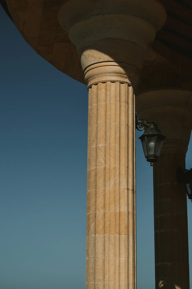 Classical architecture column with lantern against a blue sky, reflecting heritage, structure and clear perspective