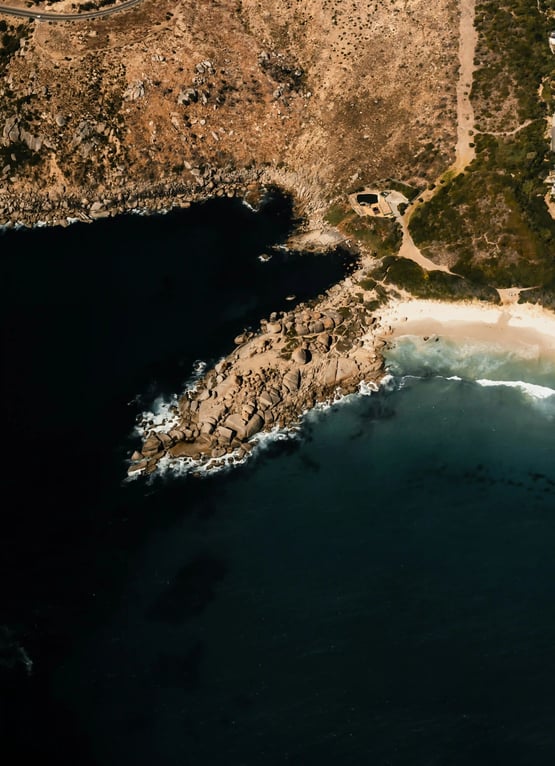 Rocky outcrop beside a beach and deep blue sea, reflecting perspective, stability and calm guidance