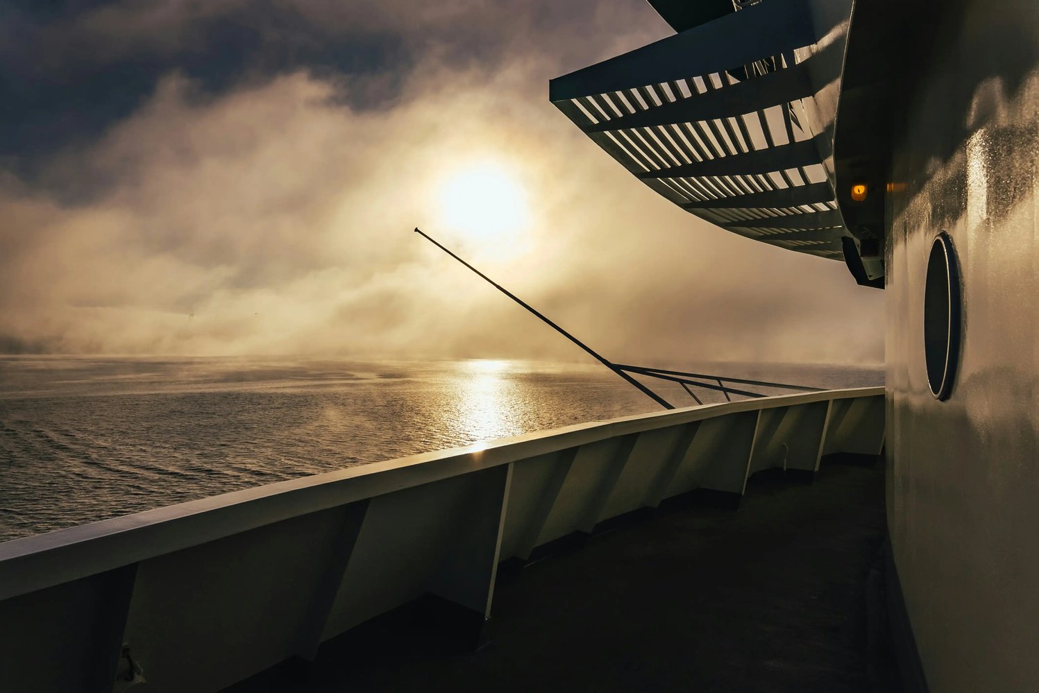 view-from-boat-sailing-through-mist-with-low-sun